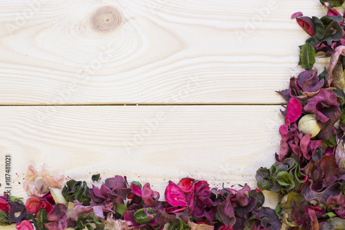 Wooden background with a corner of petals and leaves