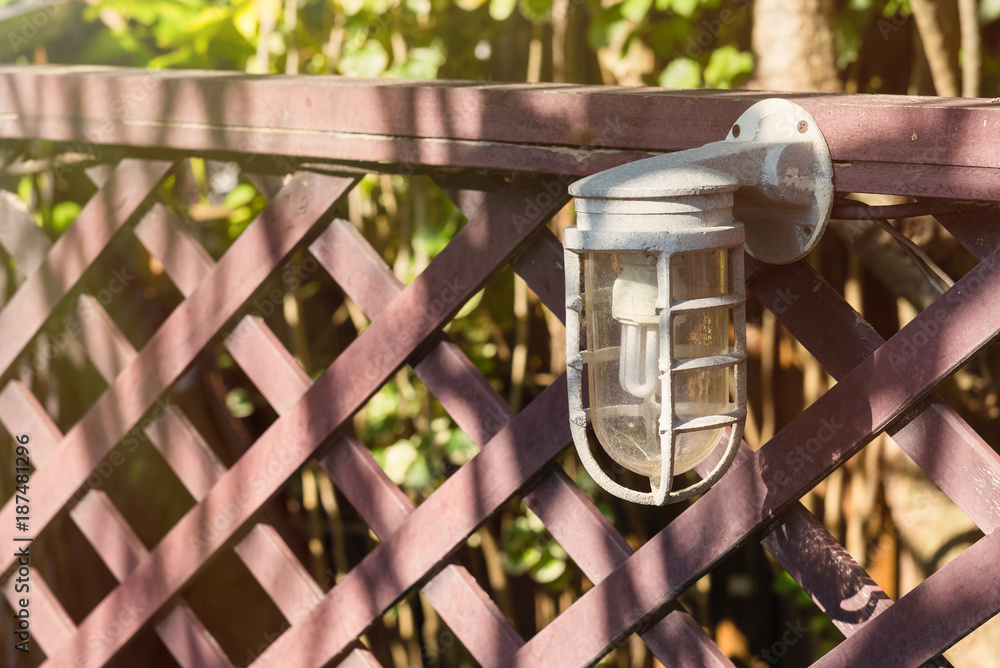 Lamps for illumination on a wooden fence in the garden.