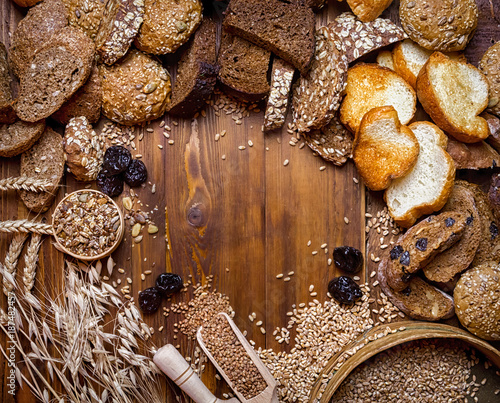 Assortment of baked bread on wooden table background