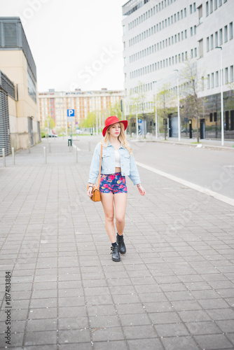 Young beautiful blonde caucasian girl walking in the city