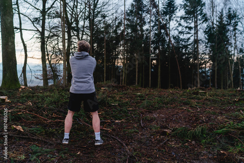 Young man doing workout with some wood in a forrest in Austria