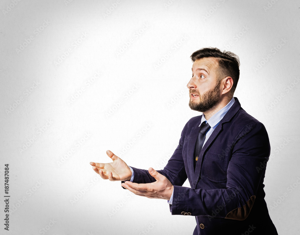 Emotional dialogue of a man in a suit. Portrait of a bearded man on a light background. Emotional dialogue of a man in a suit. Portrait of a bearded man on a light background.