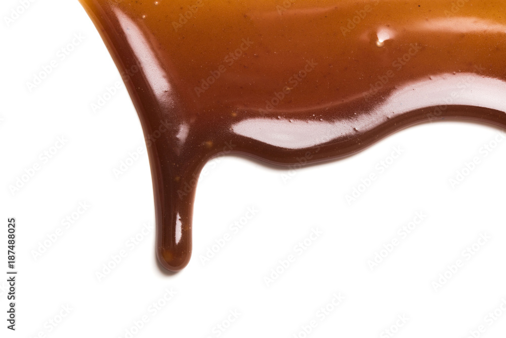 Chocolate caramel sauce drop on a plain white backround Chocolate caramel sauce drop on a plain white backround