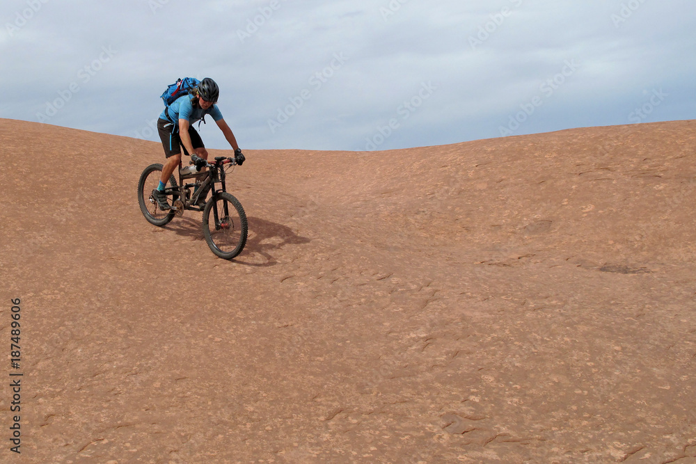 Mountain biker riding downhill the famous Slickrock trail, Moab, Utah, USA
