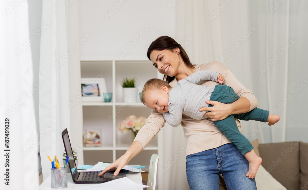 Fototapeta premium happy mother with baby and laptop working at home