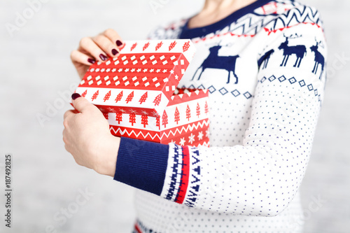 Christmas gift box in female hands, clopse up view photo