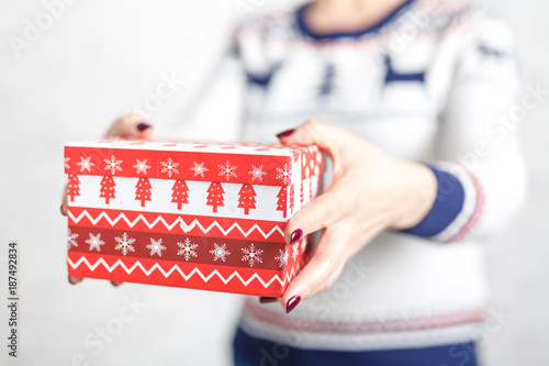 Christmas gift box in female hands, clopse up view photo