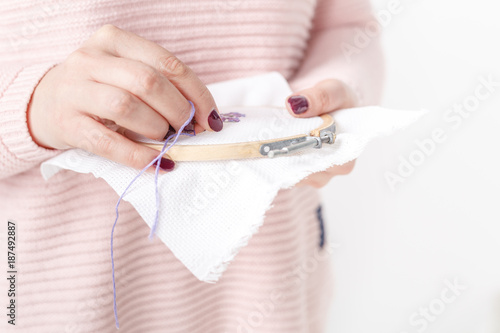 cross-stitched pillow in female hands