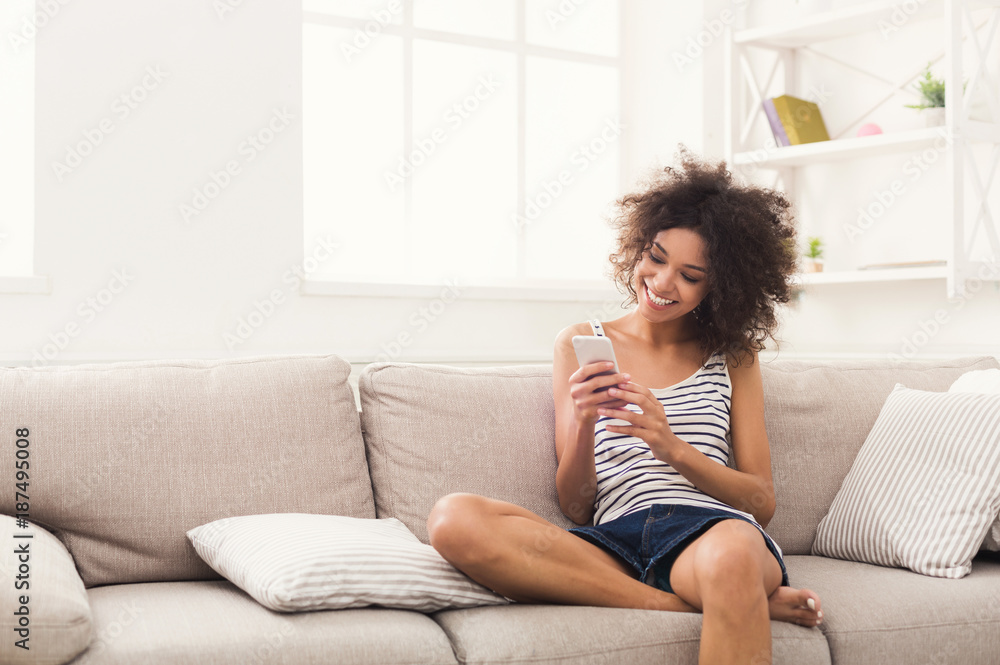 Young girl using mobile phone on sofa Young girl using mobile phone on sofa