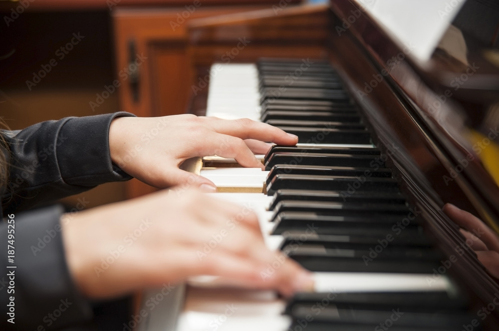 Obraz premium A girl plays a piano at home. Close up