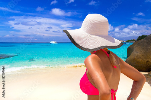 Beautiful woman in white hat on the tropical beach