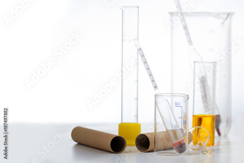 Glass thermometer and a hydrometer along with a laboratory glass on a light background photo