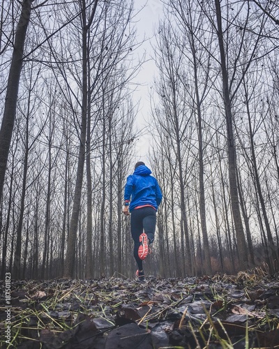 uomo che corre nel bosco