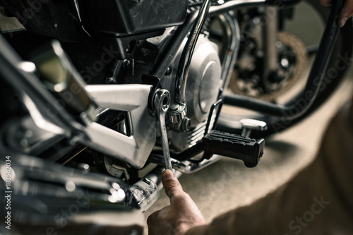 Biker's hands holding wrench near motorcycle © oksanazahray