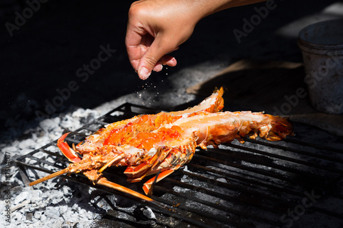 Salting lobster, preparing for grill, Croatia.