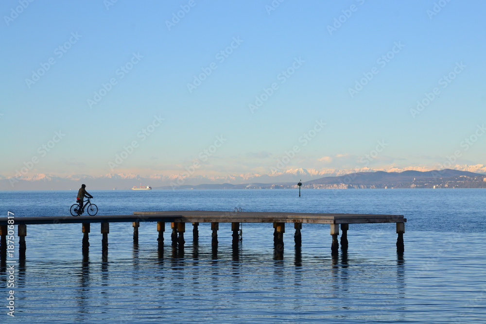Trieste - in bicicletta di inverno sul molo Trieste - in bicicletta di inverno sul molo