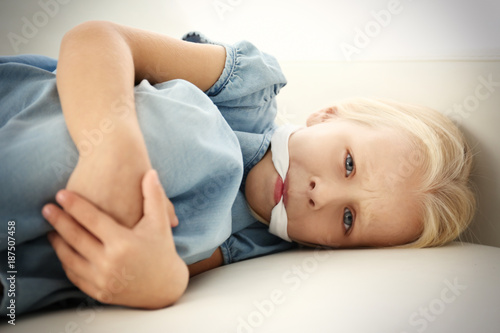 Helpless little girl lying with gag in mouth. Child abuse concept