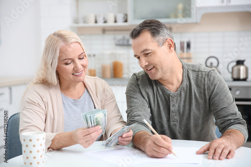 Mature couple managing family budget at home