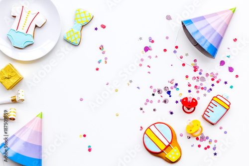 Baby shower. Cookies in shape of accesssories for child and party hats on white background top view copy space