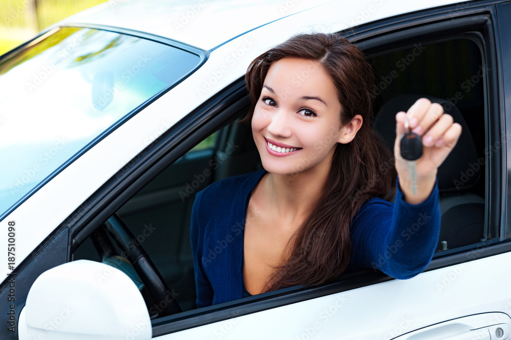 Happy female driver showing car key