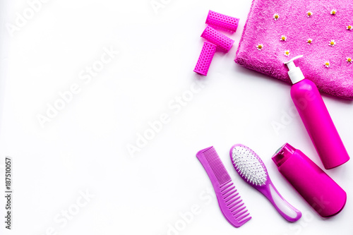 Basic hair care in bathroom. Comb, shampoo, spray, curlers, towel on white background top view copy space