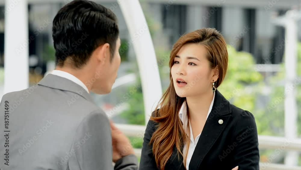 Angry business man talking violently with woman. Young chinese man and woman argue strongly and in public place. Business conflict concept. Angry business man talking violently with woman. Young chinese man and woman argue strongly and in public place. Business conflict concept.