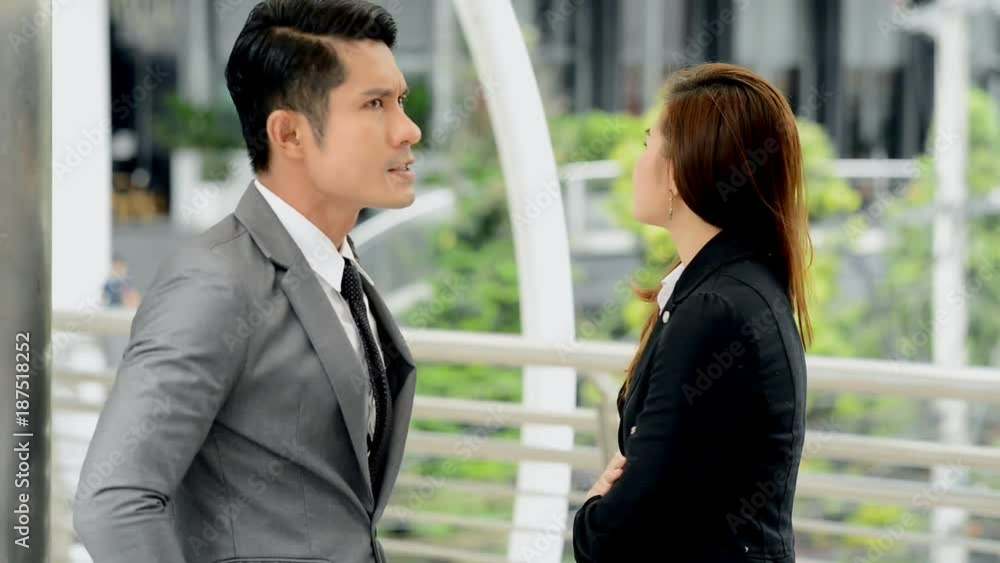 Angry business man talking violently with woman. Young chinese man and woman argue strongly and in public place. Business conflict concept. Angry business man talking violently with woman. Young chinese man and woman argue strongly and in public place. Business conflict concept.