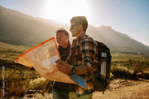Young couple reading map on country walk
