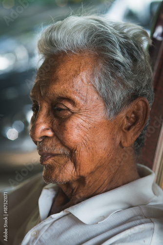 Asian old man sitting on chair photo