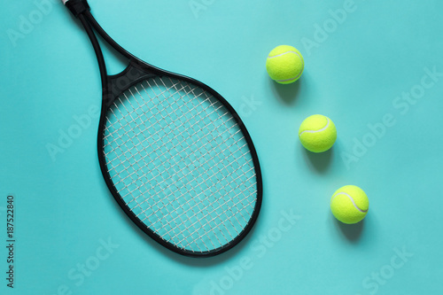Tennis balls and racket on blue background. Sport equipment. Flat lay.