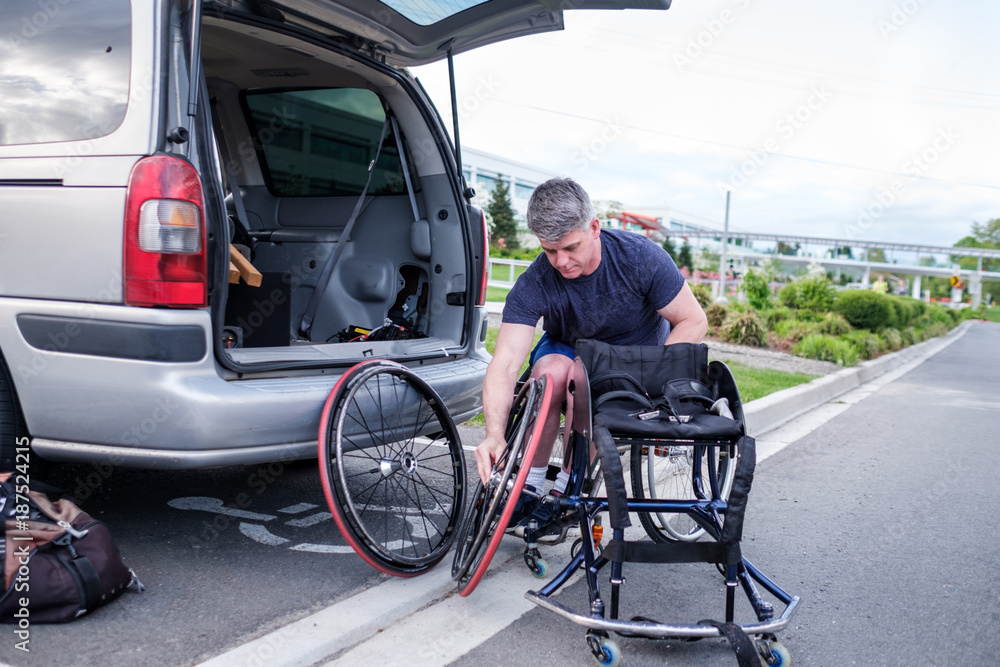 Active Disabled Athlete Taking Out Wheelchair From His Car Active Disabled Athlete Taking Out Wheelchair From His Car