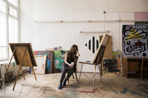 Young painter resting in her studio photo