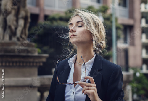 Portrait of relaxed woman with her eyes closed in classic suit