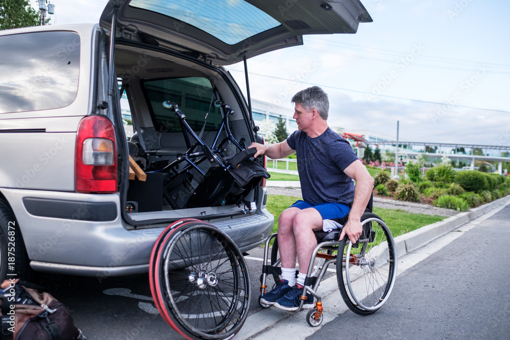 Active Disabled Athlete Taking Out Wheelchair From His Car Active Disabled Athlete Taking Out Wheelchair From His Car