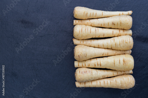 Tableau sur toile Fresh raw parsnips on dark background with copy space