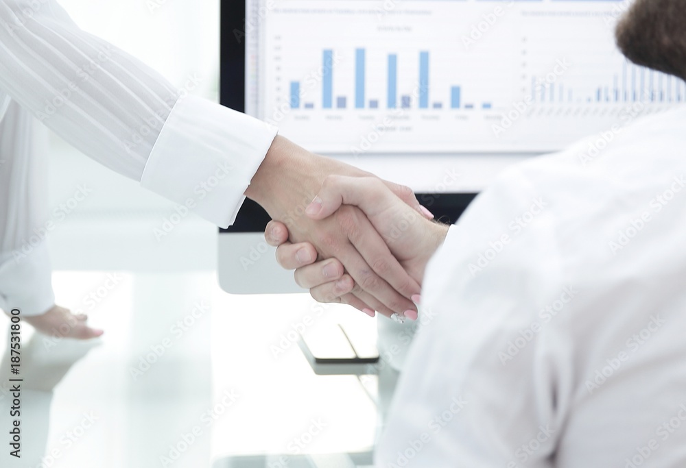 employees greet each other with a handshake near the desk employees greet each other with a handshake near the desk