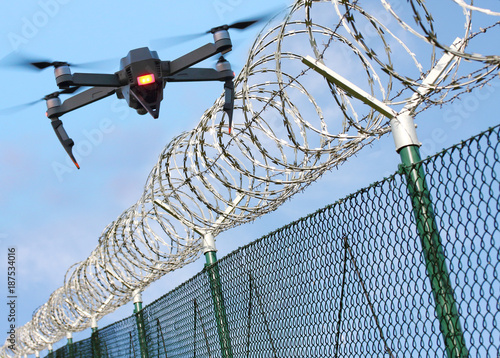 Drone monitoring barbed wire fence on state border or restricted area. Modern technology for security.