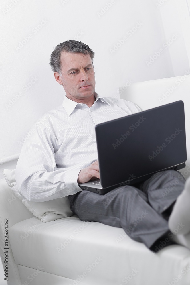 businessman working on laptop while sitting in a hotel room businessman working on laptop while sitting in a hotel room