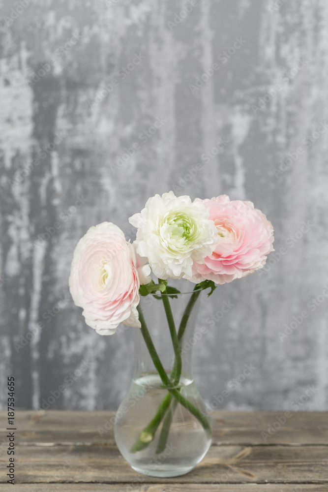 Vase with beautiful bouquet of ranunculus flowers on wooden table. rustic background with copy space. Close up Persian buttercup flower. Vase with beautiful bouquet of ranunculus flowers on wooden table. rustic background with copy space. Close up Persian buttercup flower.