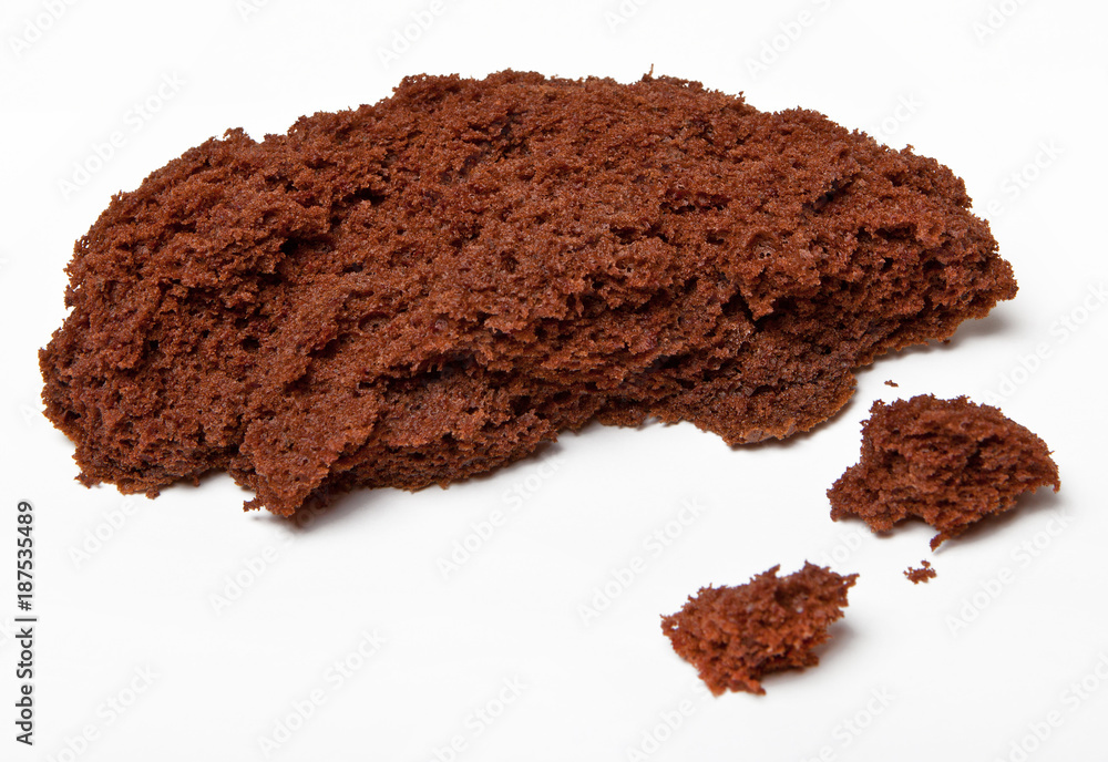 A piece of broken chocolate cake on white background A piece of broken chocolate cake on white background