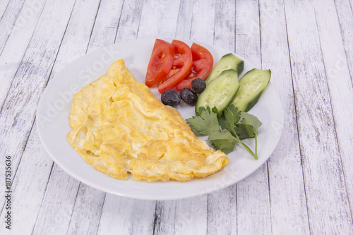Omlet with vegetable on the wood table