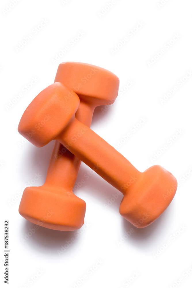 Two orange dumbbells lie on top of each other on a white background Two orange dumbbells lie on top of each other on a white background