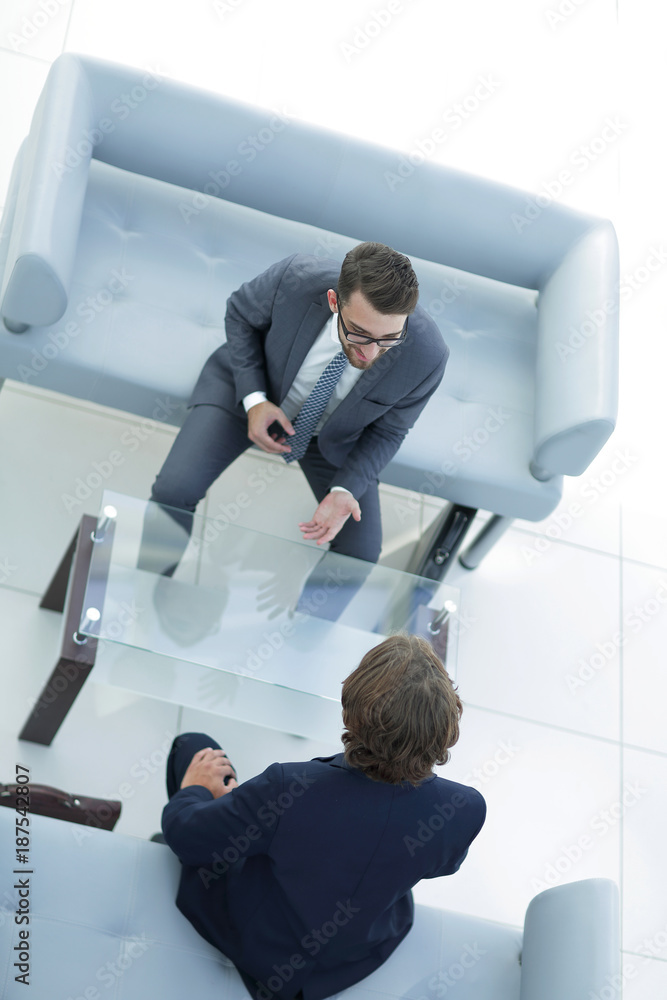 Two serious businessman talking in office. Two serious businessman talking in office.
