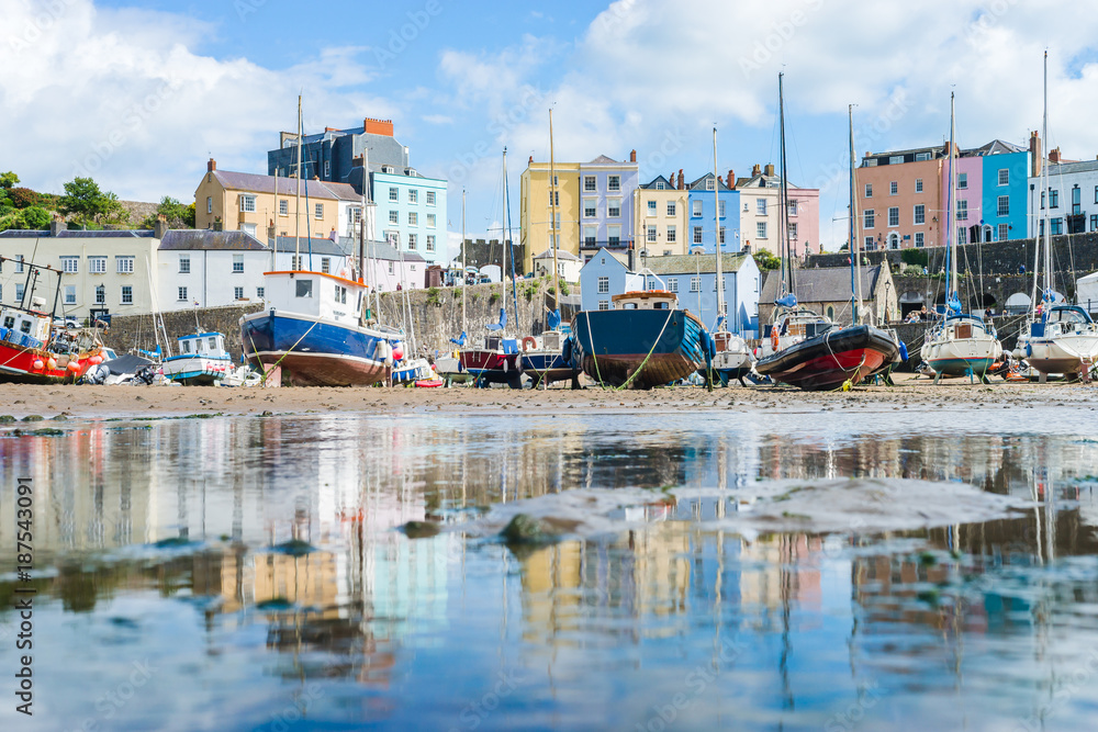 Boats in the bay at low tide with town view in Tenby bay, Wales