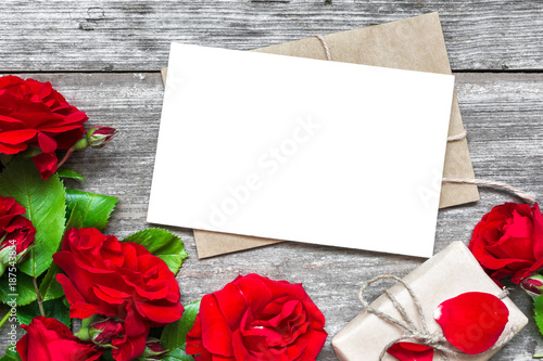 Fototapeta Naklejka Na Ścianę i Meble -  blank white greeting card with red rose flowers bouquet and envelope with gift box
