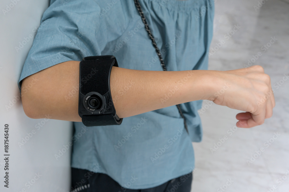Asian woman wearing black elbow brace to reduce pain Asian woman wearing black elbow brace to reduce pain