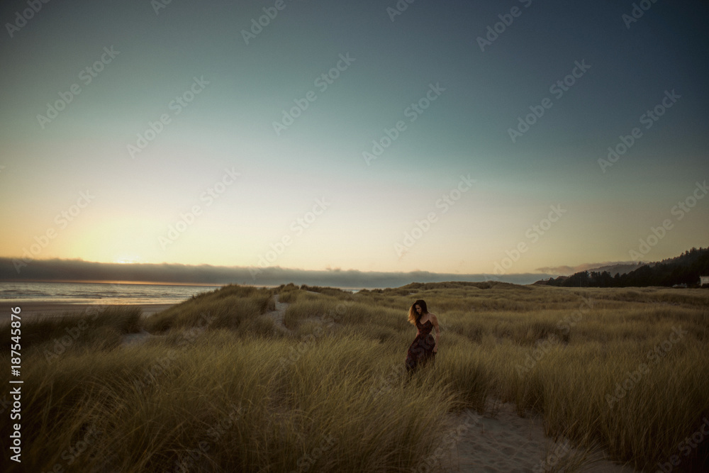 Pretty girl runs through field near beach Pretty girl runs through field near beach