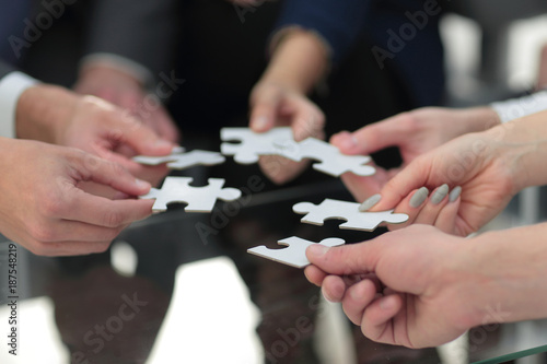 Business people holding jigsaw puzzle.