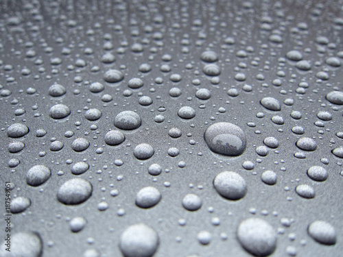 water dew droplets on silver metallic paint background. rain water droplets on car boot. weather concept