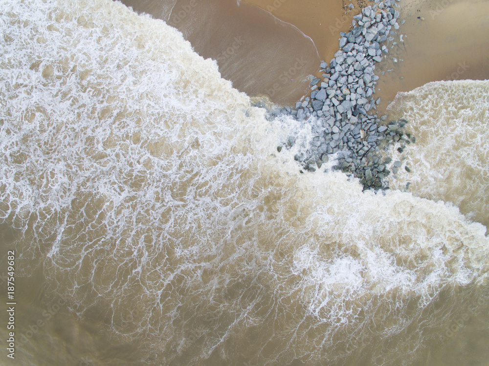Aerial top view of sea waves hitting rocks on the beach in Pantai ...